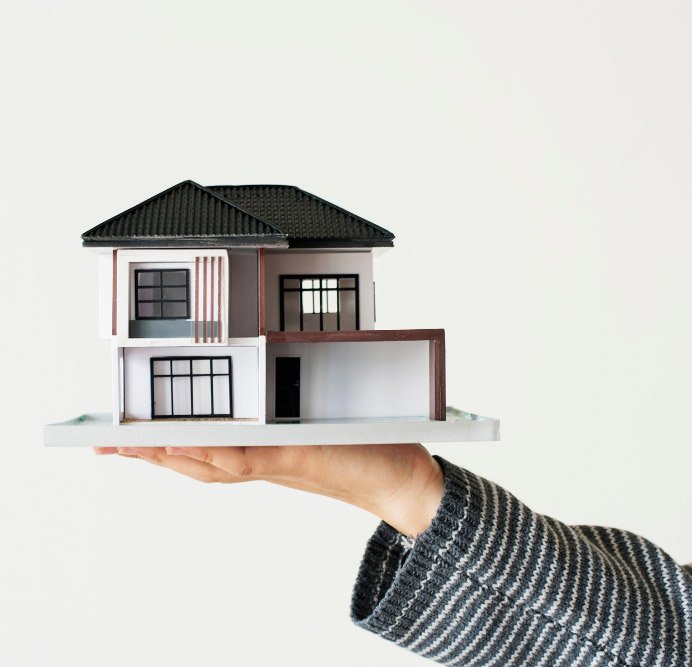 Mão apresentando casa modelo